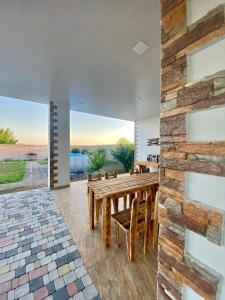 a dining room with a wooden table and a stone wall at Voskevaz Rest in Voskevaz