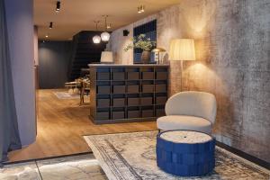 a living room with a chair and a table at Martis Forum Heritage Hotel & Residence in Poreč