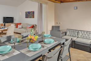 cocina y sala de estar con mesa y sillas en Villetta d'Arancia - SHERDENIA Luxury Apartments en Marinella