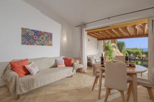 ein Wohnzimmer mit einem Sofa und einem Tisch in der Unterkunft Villetta d'Arancia - SHERDENIA Luxury Apartments in Marinella