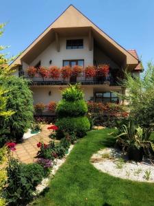 a house with flowering plants on the balcony at Casa Mona in Oradea