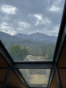 a window in a room with a view of a mountain at El Contemplatorio in Tiltil