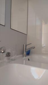 lavabo blanco con espejo y lavabo en Alojamento Local Verde e Mar, en Comporta