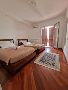 um quarto com 2 camas e piso em madeira em Residenza Estea em Tropea