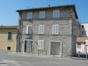 un antiguo edificio de piedra en la esquina de una calle en Affittacamere le Tre Sorelle, en Sirolo