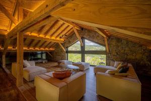 a living room with couches and a stone wall at Le 11 des Bouchaux, Gîte d'exception in La Bresse