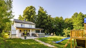 Un patio trasero con una casa y un tobogán azul. en Greenwood 84, en Kelemen