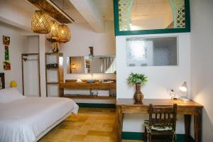 a bedroom with a bed and a desk and a bathroom at El Despertar Hotel in Jericó