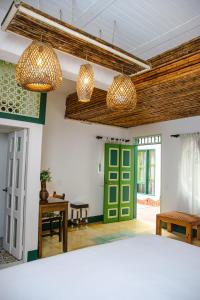 a room with a green door and two chandeliers at El Despertar Hotel in Jericó