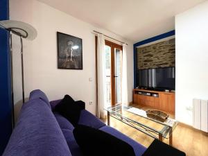 a living room with a purple couch and a tv at Apartamento ARS Rialp in Rialp