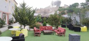um pátio com cadeiras coloridas, mesas e árvores em بيت السلطانة للشقق الفندقية شمال محافظة النماص em Ash Shaykh