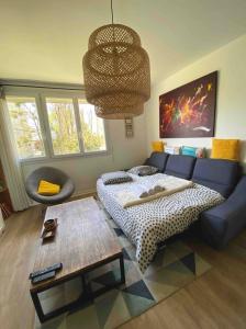 - un salon avec un lit et un canapé bleu dans l'établissement Superbe appartement au calme avec parking gratuit., à Mérignac