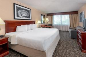 a hotel room with a large bed and a television at Capitol Plaza Hotel Jefferson City in Jefferson City