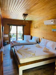 two beds in a room with wooden walls at 7 Green Adrasan in Adrasan