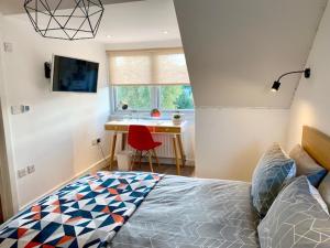 a bedroom with a bed and a desk with a red chair at 72 Ashley Road in Newmarket