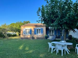 Camaret-sur-AiguesにあるLa Villa de l'Ayguesの庭のテーブルと椅子付きの家