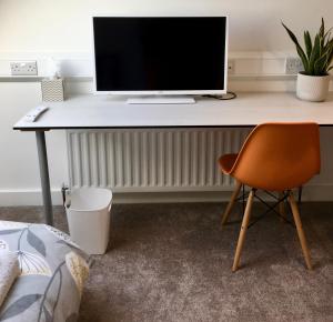 escritorio con monitor y silla en la habitación en 72 Ashley Road, en Newmarket