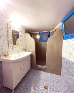 a bathroom with a sink and a mirror at Gemini Cave Villa in Oia