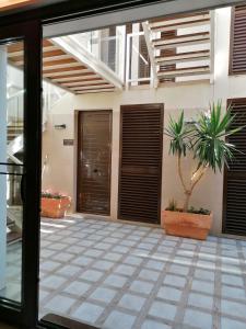 an open glass door of a house with a potted plant at HOTEL ISLA PLANA in Tabarca