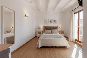 Dormitorio blanco con cama y ventana grande en Hotel La Sitja - Adults only, en Benisoda