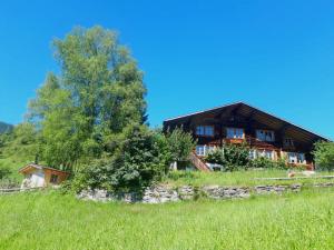 ein Holzhaus auf einem Hügel mit einem grünen Feld in der Unterkunft Breitmoos in Hasliberg