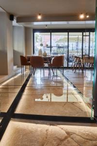 a dining room with a table and chairs on a floor at Martis Forum Heritage Hotel & Residence in Poreč