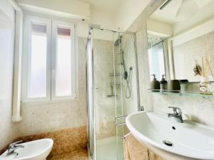 ein Bad mit einem Waschbecken und einer Glasdusche in der Unterkunft Suite Astraldi - a 2 minuti dall'Ariston in Sanremo