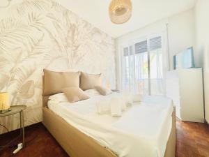 ein Schlafzimmer mit einem großen weißen Bett und einem Wandbild in der Unterkunft Suite Astraldi - a 2 minuti dall'Ariston in Sanremo
