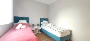 a room with two beds in a room at Masurian Apartments in Mrągowo