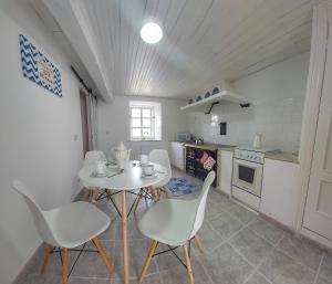 a kitchen with a table and chairs in a room at Villa Flor Armenteira in Armentera