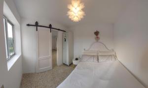 Habitación blanca con cama y lámpara de araña. en Villa Flor Armenteira, en Santa María