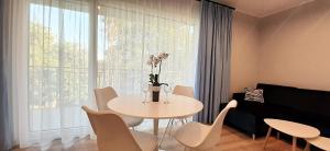 sala de estar con mesa, sillas y ventana en Masurian Apartments en Mrągowo