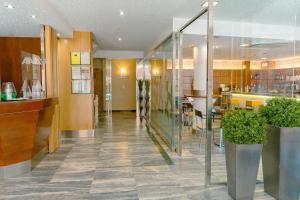 a lobby of a restaurant with a bar and tables at Hotel Atalaya I in Portonovo