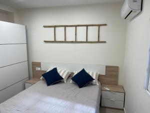 Dormitorio pequeño con cama con almohadas azules en La Casita del Pescador en Caleta De Velez