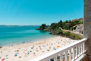 una vista de una playa con gente en ella en Hotel Atalaya I, en Portonovo