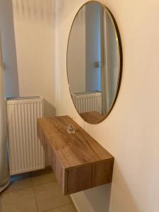 y baño con mesa de madera y espejo. en Bright Luxury Apt., en Volos