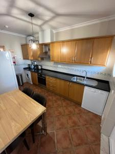 a kitchen with wooden cabinets and a table with a sink at Parra Home Holidays - Close to Galé Beach in Guia
