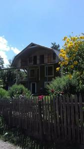 ein Haus mit einem Zaun und Blumen davor in der Unterkunft Green House Nakra in Naki