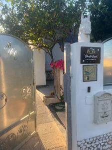 Una caja de metal con un cartel junto a un árbol. en Wonderland en San Teodoro