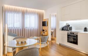 uma cozinha e sala de estar com mesa e cadeiras em Catarina Serviced Apartments em Porto