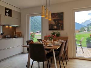 a kitchen and dining room with a table and chairs at TYROL PURElife Lodges in Sankt Jakob in Defereggen