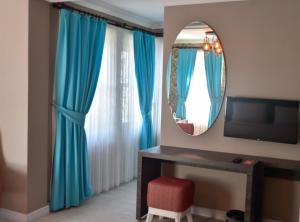 Habitación con cortinas azules y espejo. en Noya Köşk Otel en Adalar