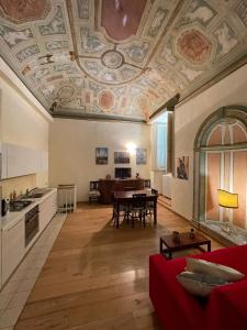 salon z czerwoną kanapą i kuchnią w obiekcie Palazzo Bianchi Bandinelli by FrancigenaApartments w Sienie