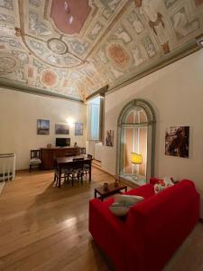salon z czerwoną kanapą i stołem w obiekcie Palazzo Bianchi Bandinelli by FrancigenaApartments w Sienie