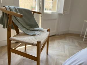 una silla de madera con una manta en un dormitorio en The MO GOTIC, en Barcelona