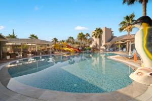ein Pool in einem Resort mit einem schwimmenden Pinguin in der Unterkunft Aeolos Beach Resort in Malia