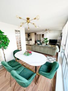 ein Wohnzimmer mit einem weißen Tisch und grünen Stühlen in der Unterkunft Luxury Belfast Stay in Belfast