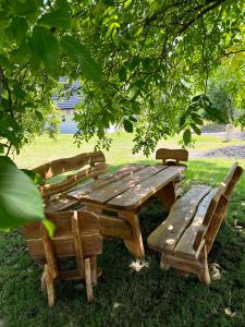 een houten picknicktafel en stoelen onder een boom bij Ubytování pod Troskami in Rovensko pod Troskami