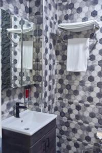 a bathroom with a sink and a mirror and towels at Noya Köşk Otel in Adalar