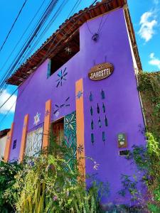 Un bâtiment violet avec un panneau sur lui dans l'établissement Jahostel, à Lençóis